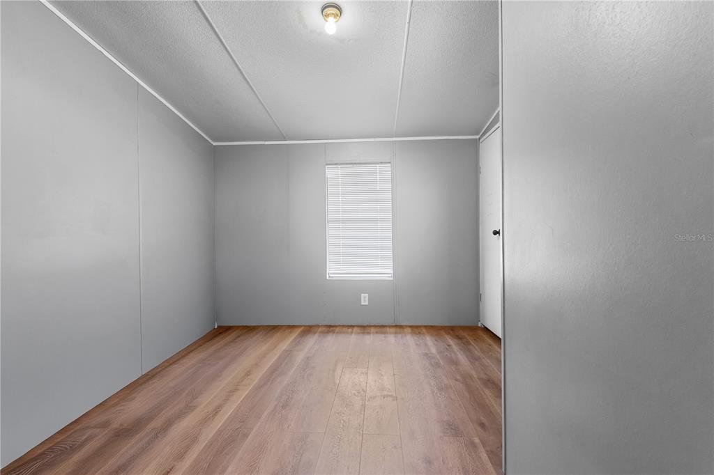 1650 Lyman Hendry Road, Unit 2 Perry, FL 32347 - Photo 5 of 26 an empty room with wooden floor and windows