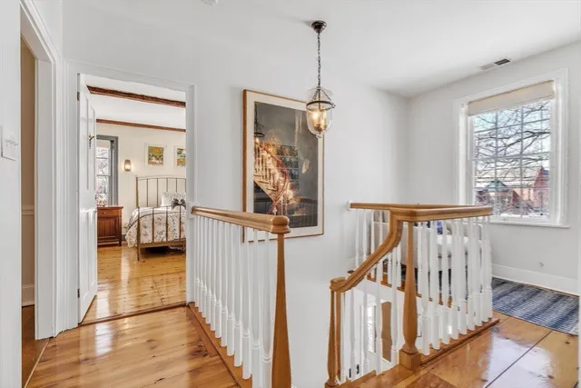 a spacious bedroom with a bed a fireplace and windows