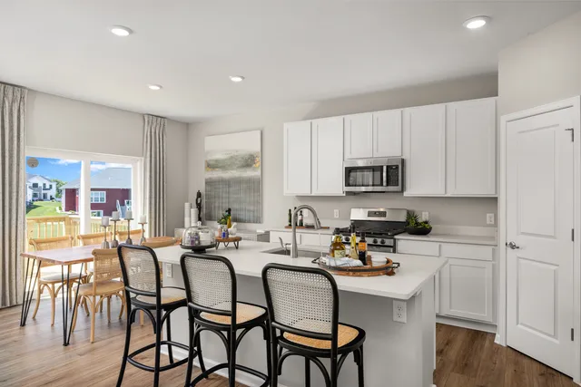 a kitchen with stainless steel appliances granite countertop a table and chairs in it
