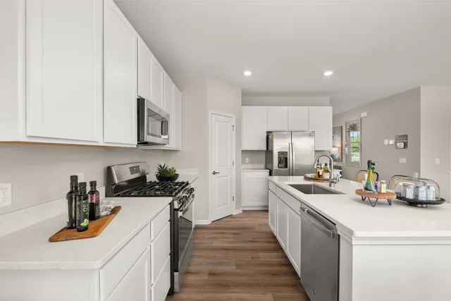 a kitchen with stainless steel appliances granite countertop a sink stove and cabinets