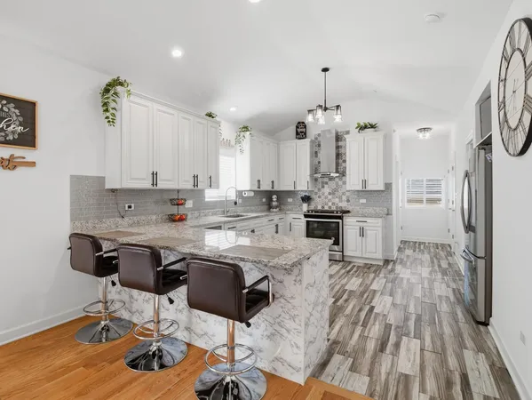 a kitchen with stainless steel appliances granite countertop a stove a sink and a microwave
