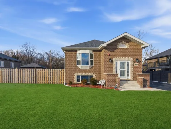 a front view of a house with a garden and yard