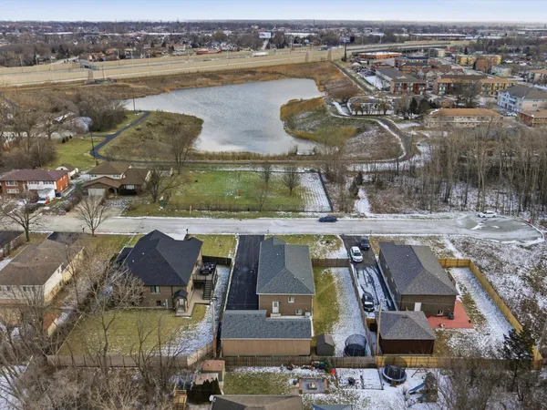 an aerial view of a residential houses with outdoor space and lake view