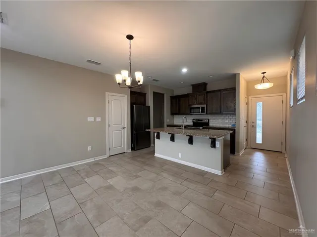 a large kitchen with kitchen island a sink stainless steel appliances and cabinets