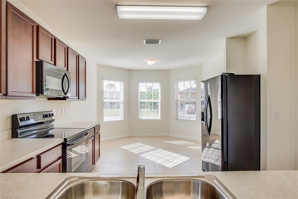 8353 Wren Road Fort Myers, FL 33967 - Photo 7 of 18 a kitchen with stainless steel appliances granite countertop a refrigerator and a sink