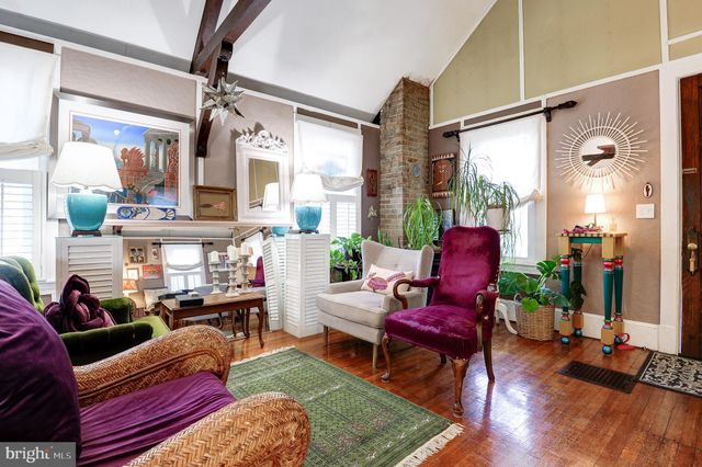 a living room with furniture fireplace and a large window