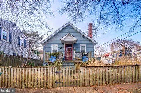 a view of a house with wooden fence next to a road