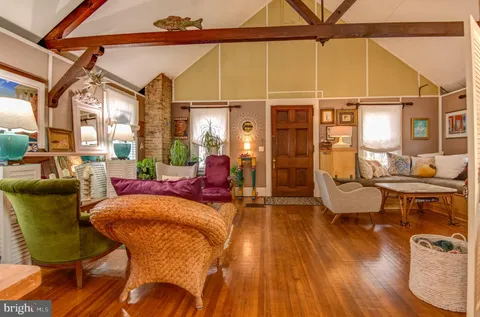 a living room with furniture a dining table and wooden floor