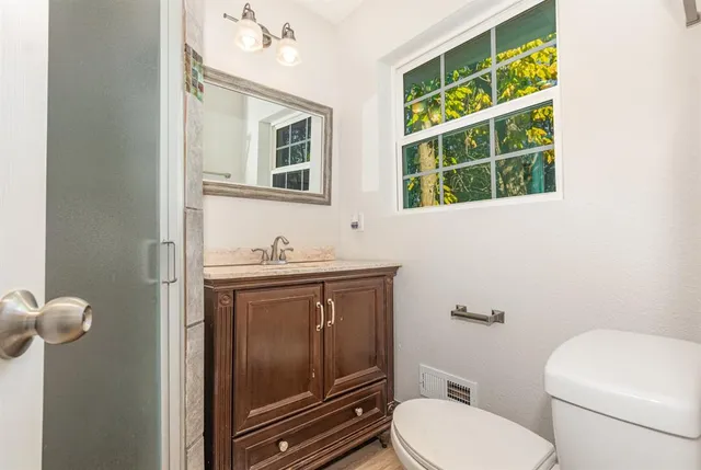 a bathroom with a toilet sink and mirror