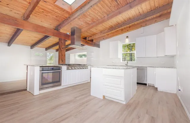 a kitchen with granite countertop white cabinets and white appliances