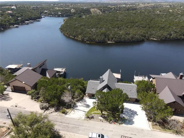 an aerial view of a house with a yard and lake view