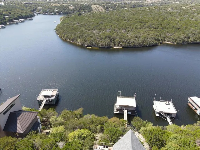 an aerial view of a house with a yard and lake view