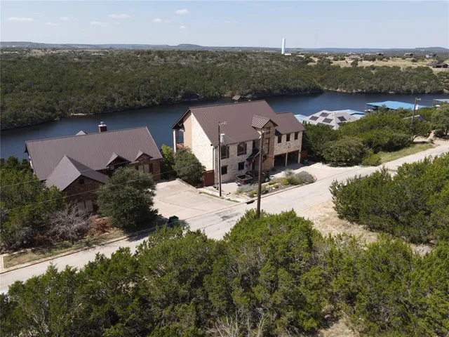 an aerial view of a house with a garden and lake view