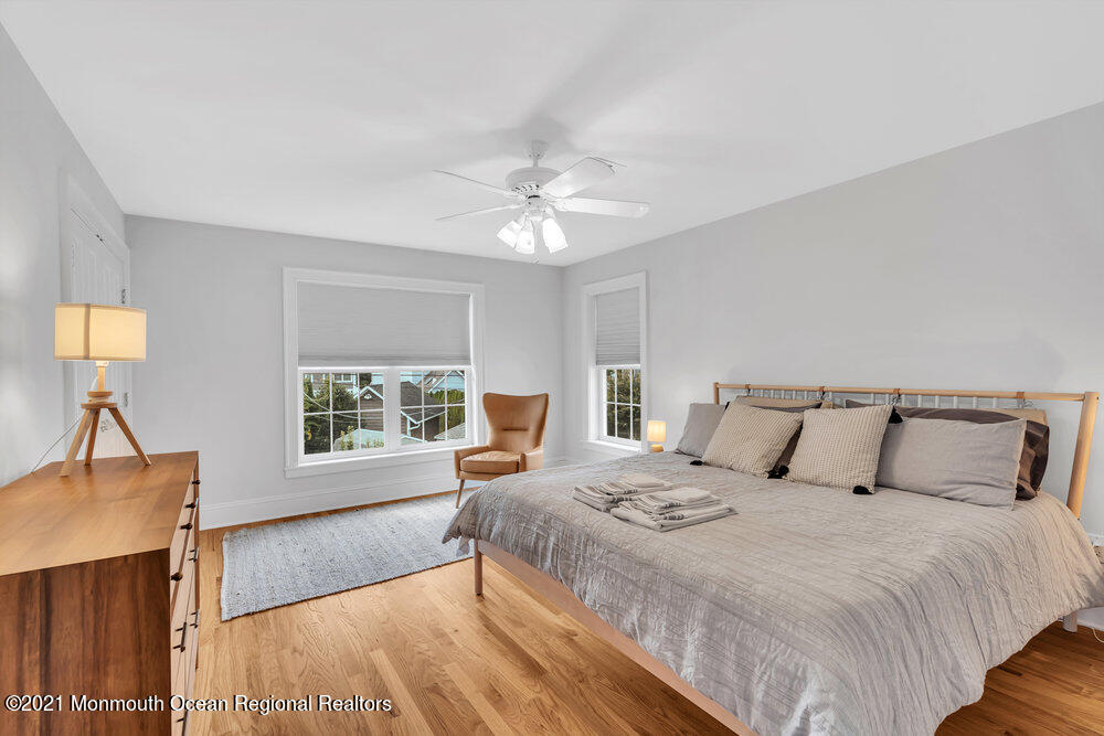 507 Washington Avenue Spring Lake, NJ 07762 - Photo 21 of 29 a bedroom with a large bed and a chandelier