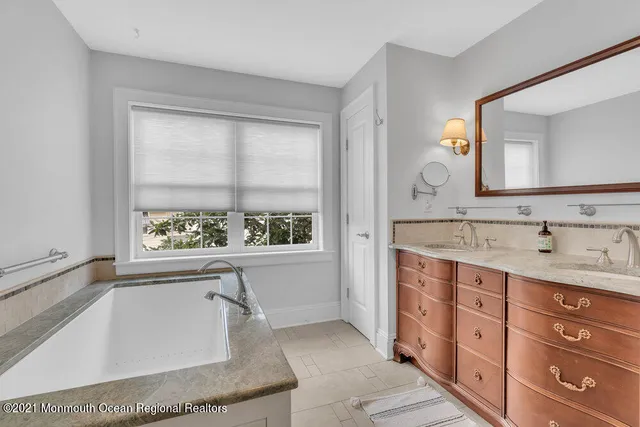 a spacious bathroom with a granite countertop tub sink and mirror