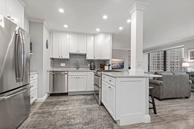 a kitchen with white cabinets and stainless steel appliances