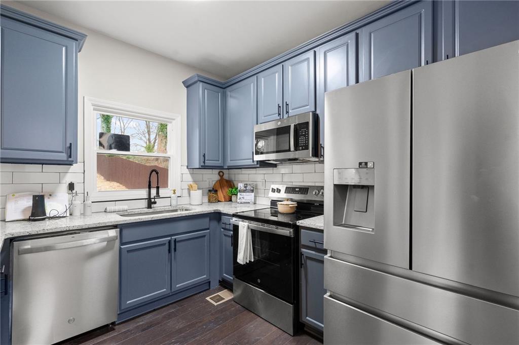 731 Dill Avenue Southwest Atlanta, GA 30310 - Photo 14 of 25 a kitchen with stainless steel appliances granite countertop a refrigerator sink and stove
