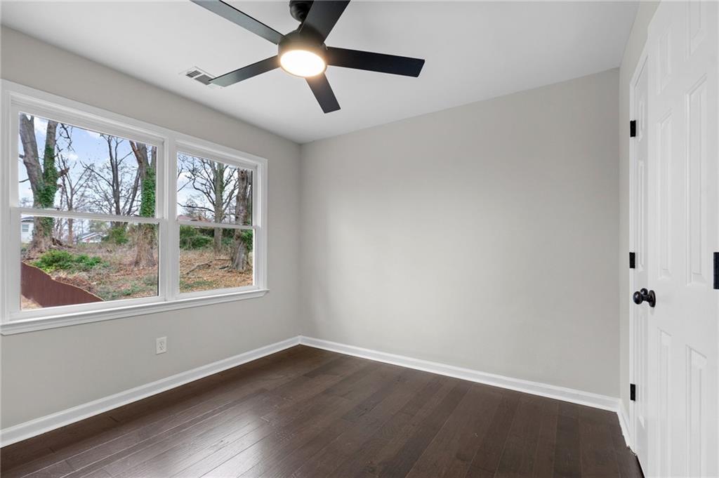 731 Dill Avenue Southwest Atlanta, GA 30310 - Photo 23 of 25 an empty room with wooden floor chandelier fan and windows