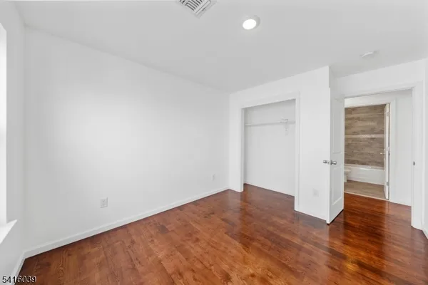 an empty room with wooden floor and doors