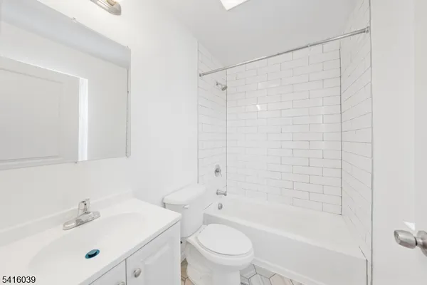 a bathroom with a bathtub shower sink vanity and toilet