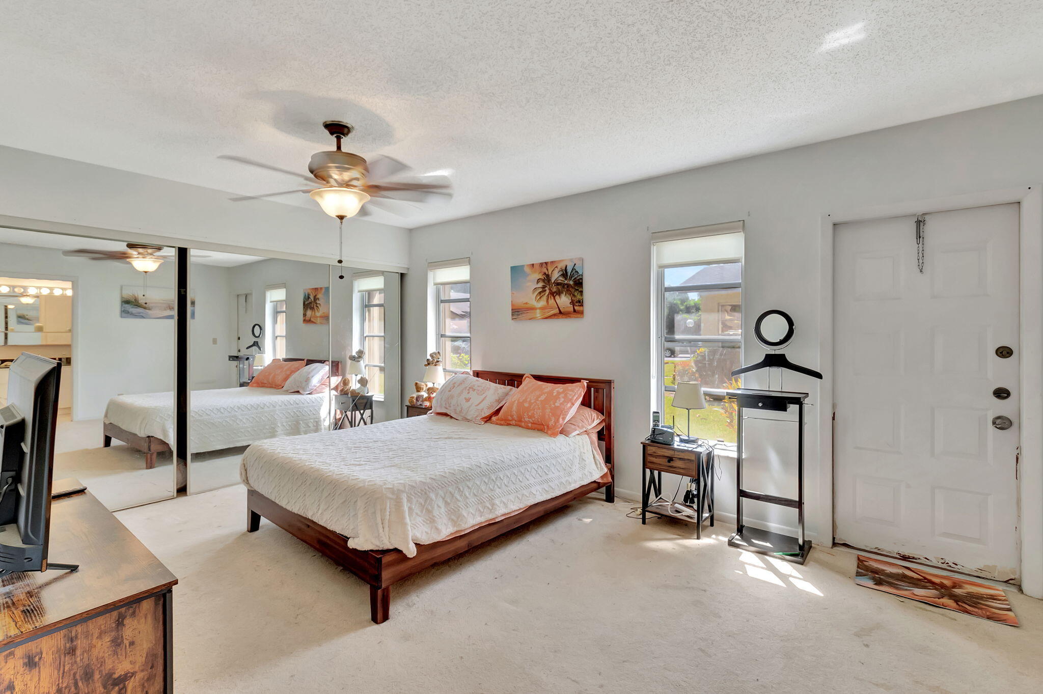 14110 Nesting Way, Unit A Delray Beach, FL 33484 - Photo 14 of 30 a bedroom with a bed a chandelier and dresser