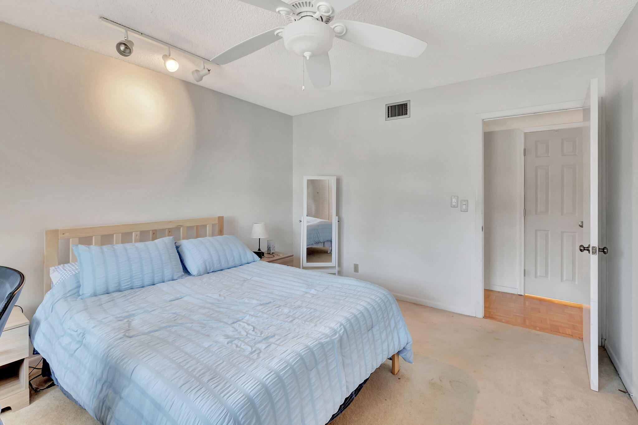 14110 Nesting Way, Unit A Delray Beach, FL 33484 - Photo 17 of 30 a bedroom with a large bed and a chandelier fan