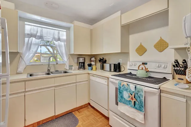 a kitchen with cabinets a stove a sink and a window
