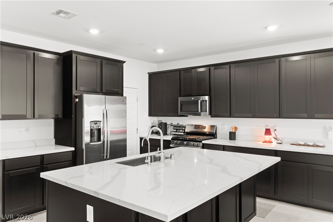 320 Isla Enclave Way Henderson, NV 89011 - Photo 3 of 49 This kitchen showcases a central island and contemporary dark cabinetry.