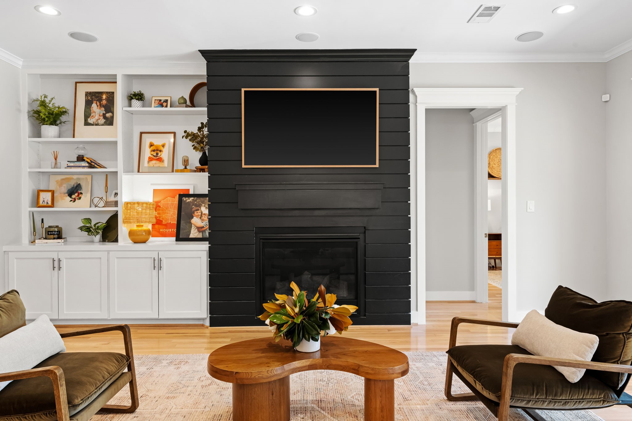 1013 Martin Street Houston, TX 77018 - Photo 13 of 46 Beautiful family room centered around a gas log fireplace w/custom shiplap surround flanked by built-in shelving & under-counter storage. Spacious open layout seamlessly connects to the kitchen & breakfast area. Door to the right leads to the primary suite.