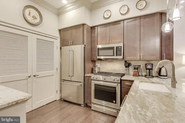 a kitchen with granite countertop a stove a refrigerator and a stove top oven