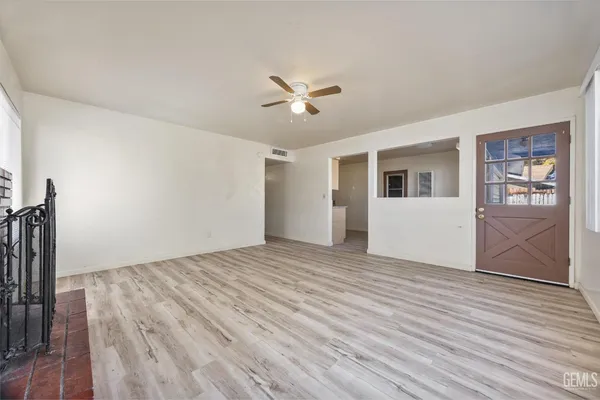 a view of a livingroom with wooden floor and a ceiling fan