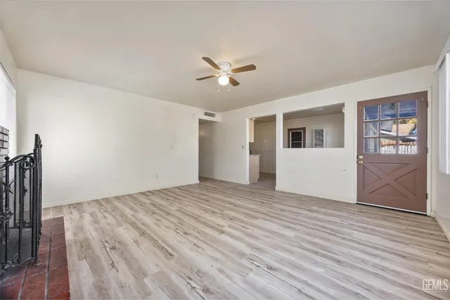 a view of a livingroom with wooden floor and a ceiling fan