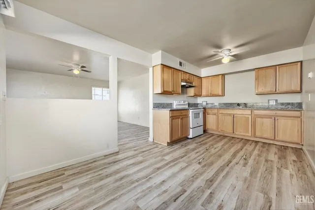 a kitchen with wooden floors and white cabinets