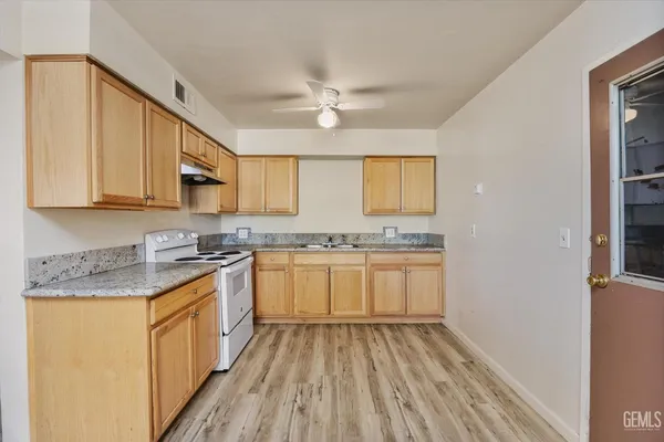 a kitchen with granite countertop white cabinets and white appliances