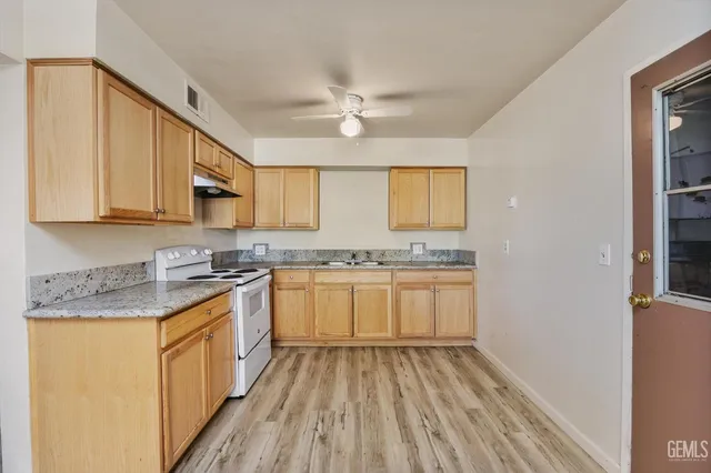 a kitchen with granite countertop white cabinets and white appliances