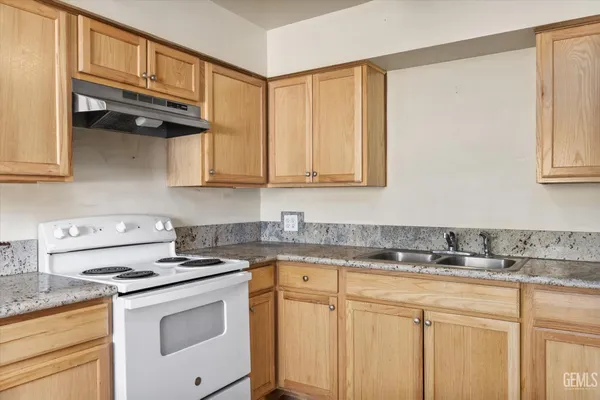 a kitchen with stainless steel appliances granite countertop white cabinets and a stove