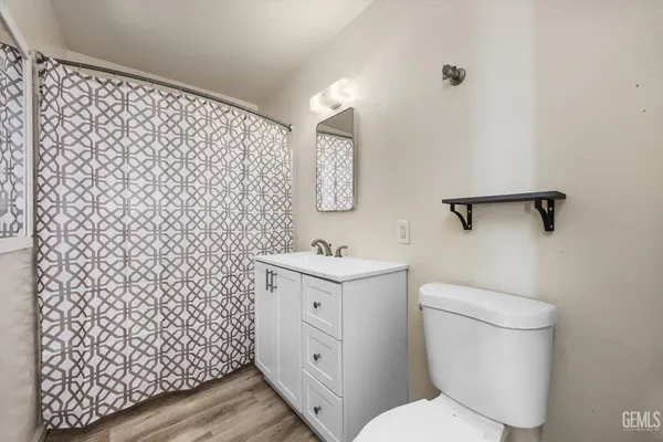 a bathroom with a granite countertop toilet and a sink