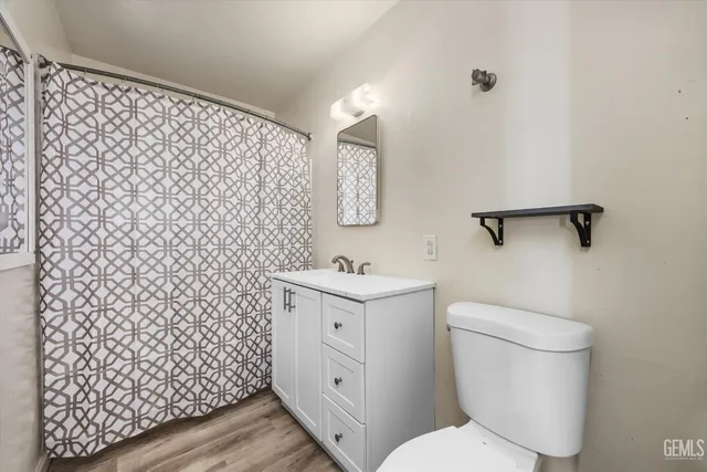 a bathroom with a granite countertop toilet and a sink