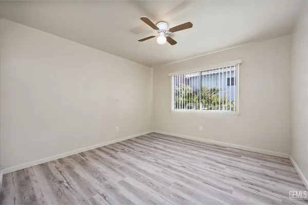 an empty room with window and ceiling fan