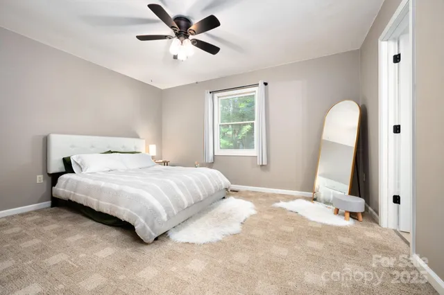 a bedroom with a bed next to a window