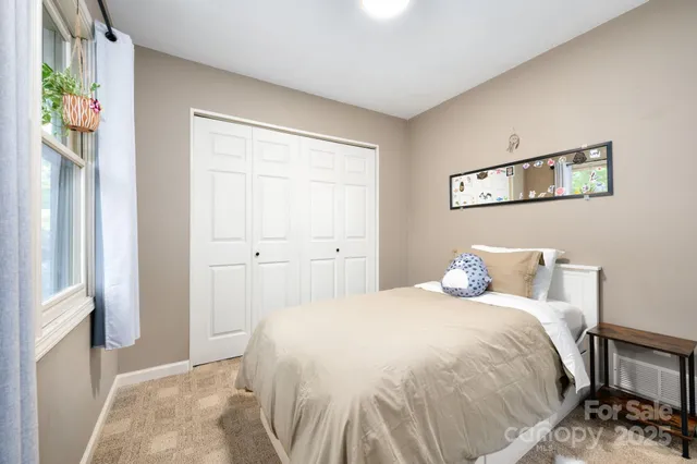 a bedroom with a bed and a window