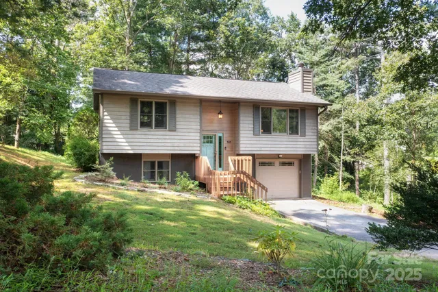 a view of a house with a yard balcony and a tree