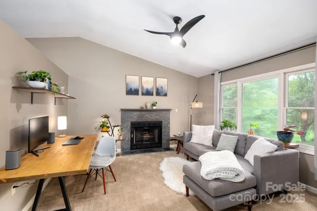 a living room with furniture a fireplace and a flat screen tv