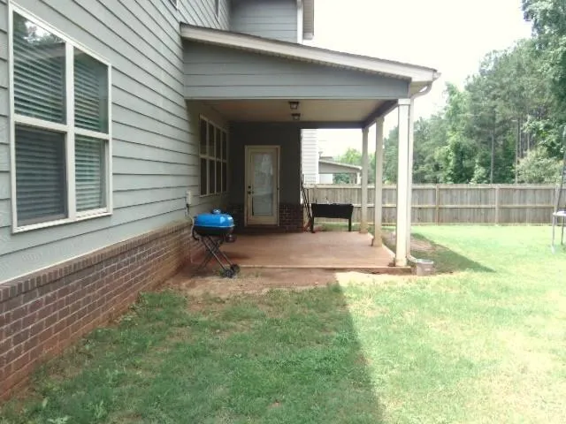 a view of a house with backyard and sitting area