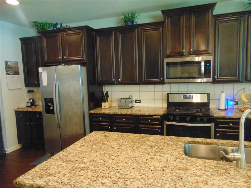 445 Piedmont Circle Covington, GA 30016 - Photo 9 of 24 a kitchen with stainless steel appliances granite countertop a refrigerator stove and microwave