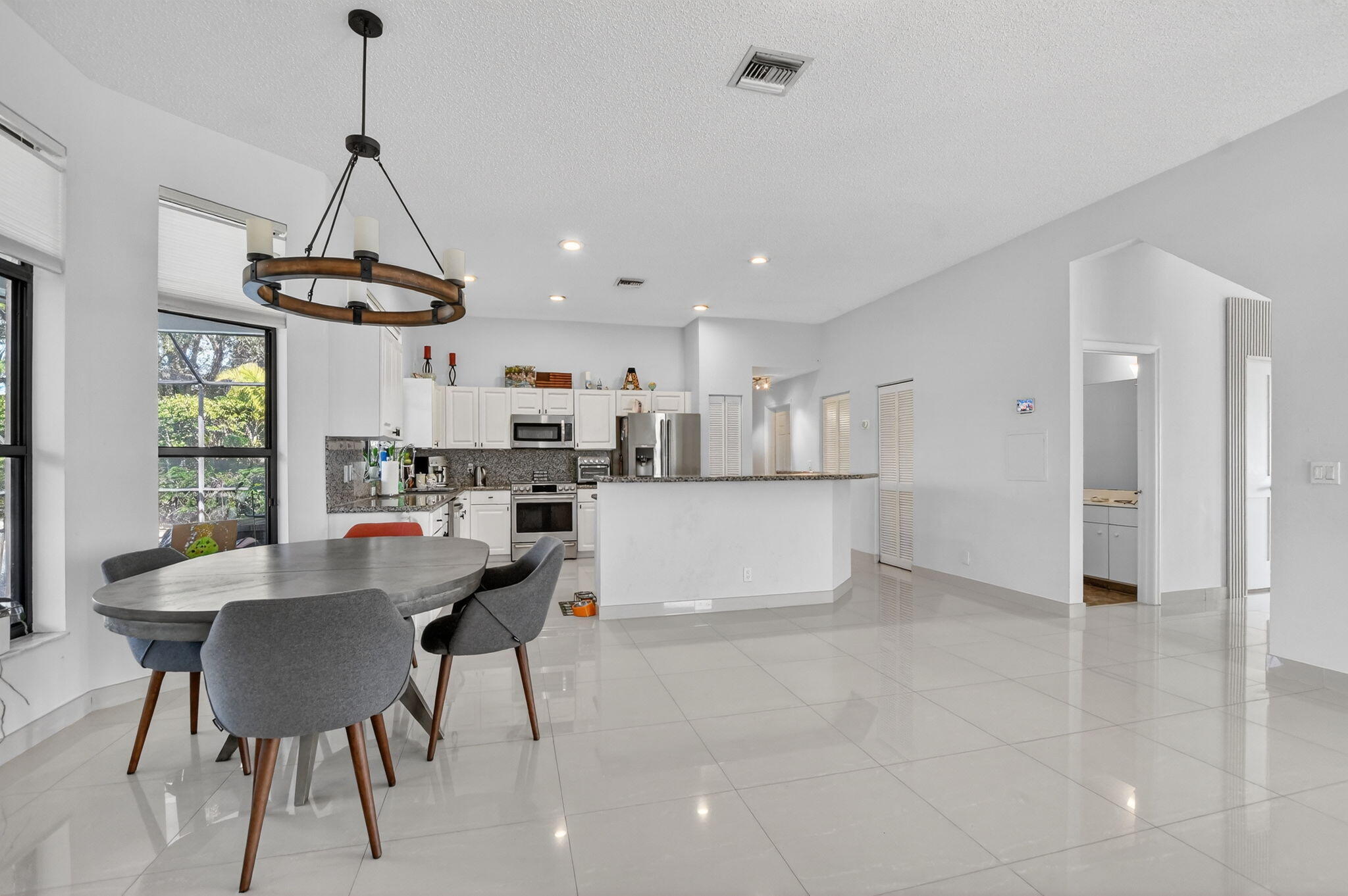 10058 Umberland Place Boca Raton, FL 33428 - Photo 14 of 55 a view of a dining room and livingroom with furniture wooden floor a chandelier