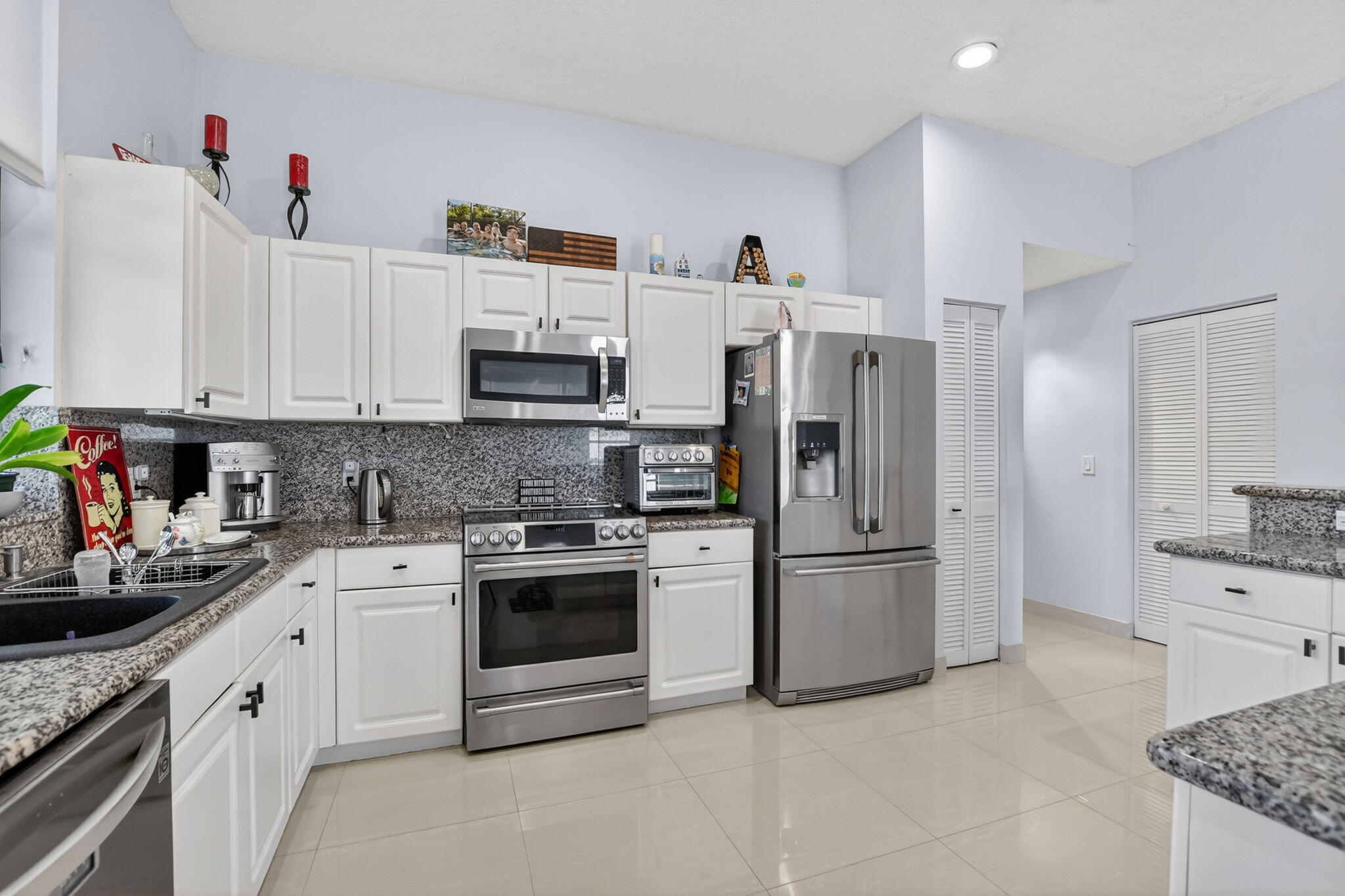 10058 Umberland Place Boca Raton, FL 33428 - Photo 17 of 55 a kitchen with stainless steel appliances granite countertop a sink stove and refrigerator