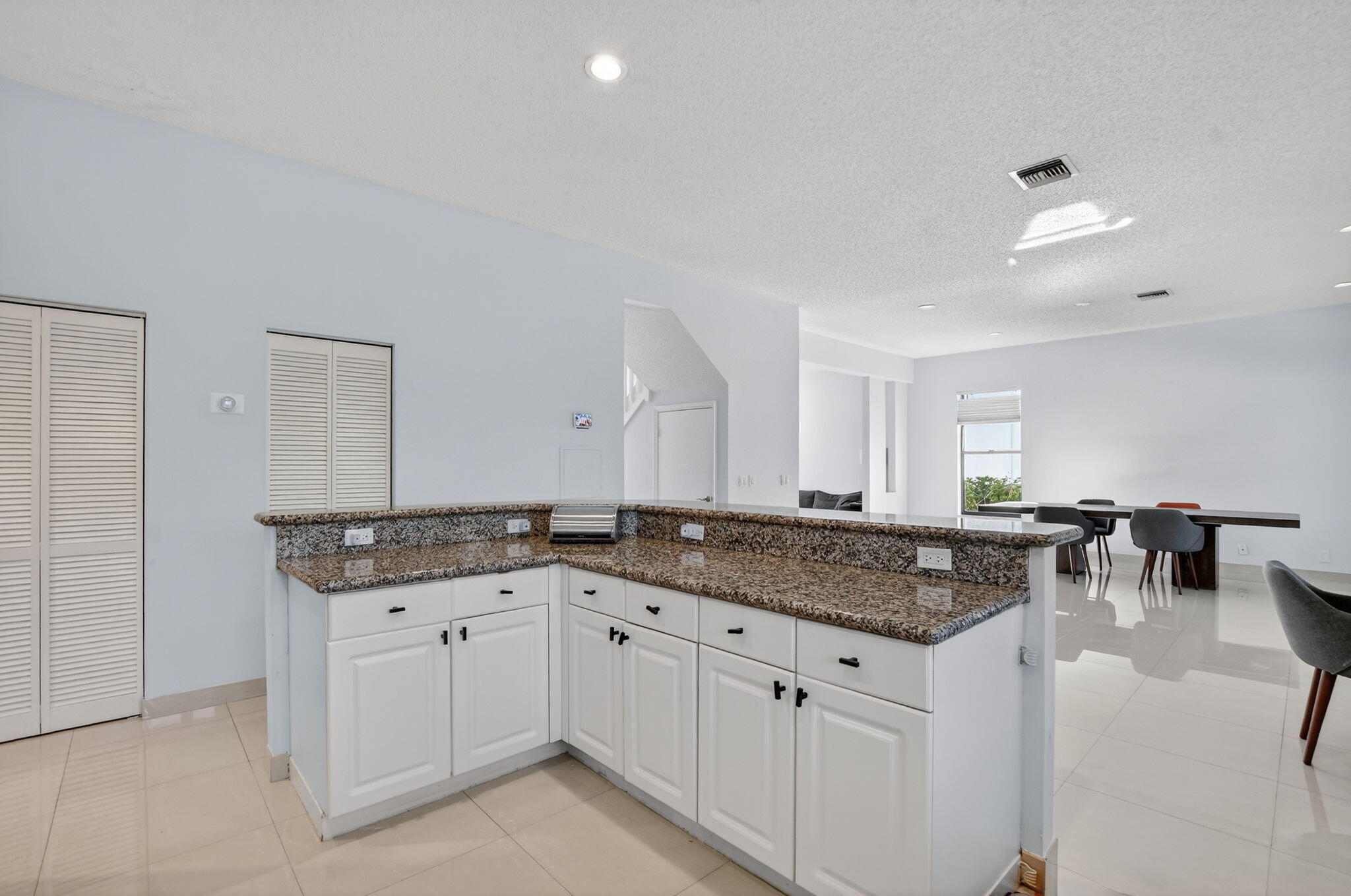 10058 Umberland Place Boca Raton, FL 33428 - Photo 18 of 55 a kitchen with granite countertop a sink and white cabinets