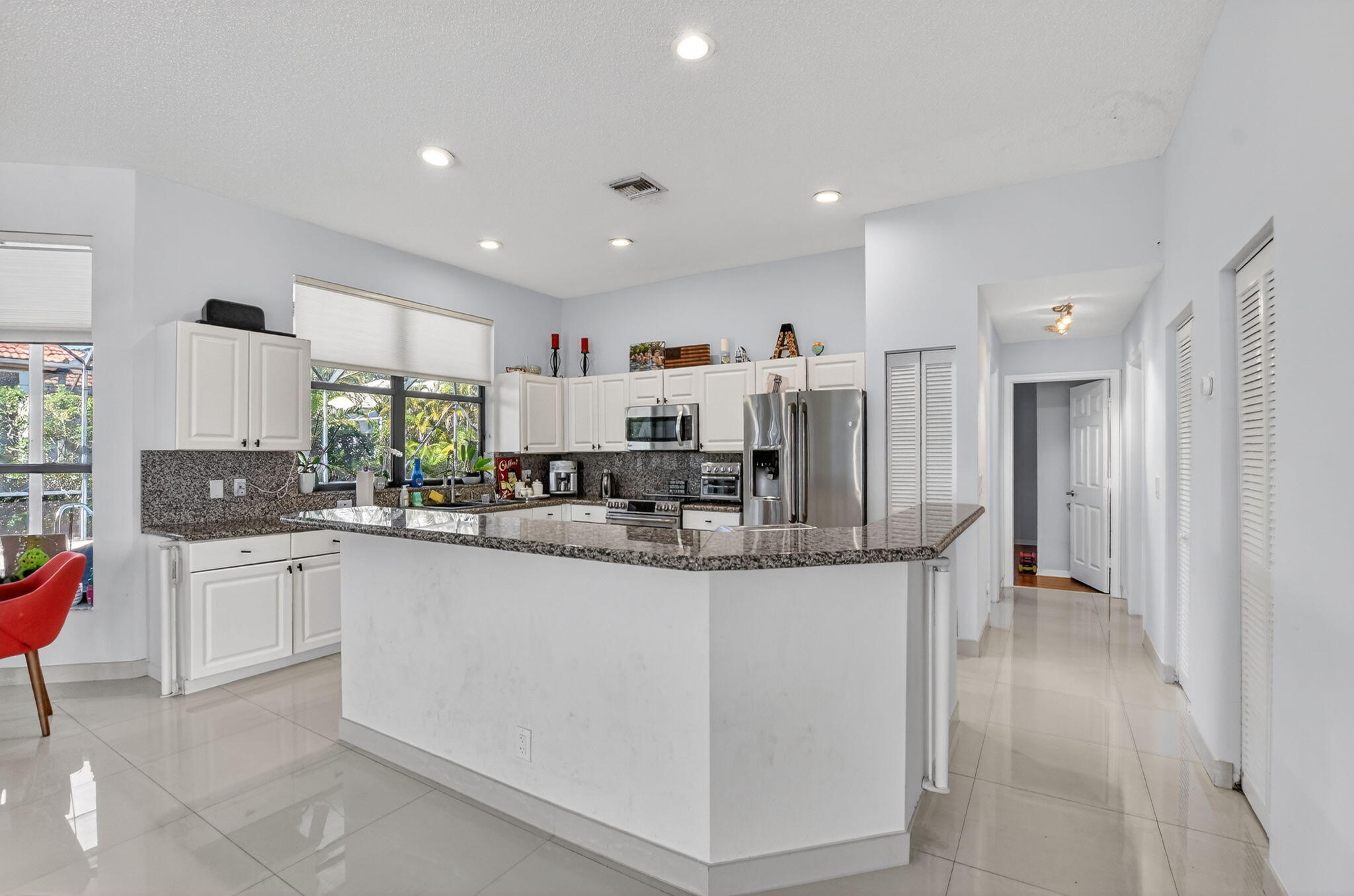 10058 Umberland Place Boca Raton, FL 33428 - Photo 20 of 55 a kitchen with stainless steel appliances kitchen island granite countertop a stove and a sink