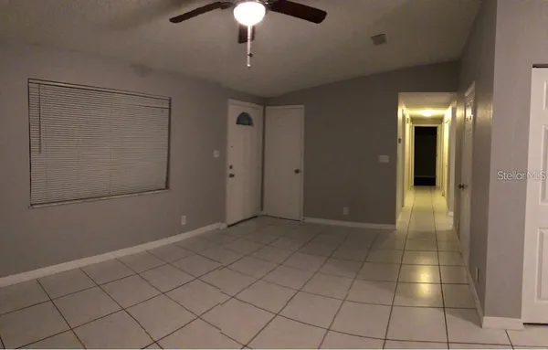 an empty room with fan and entrance